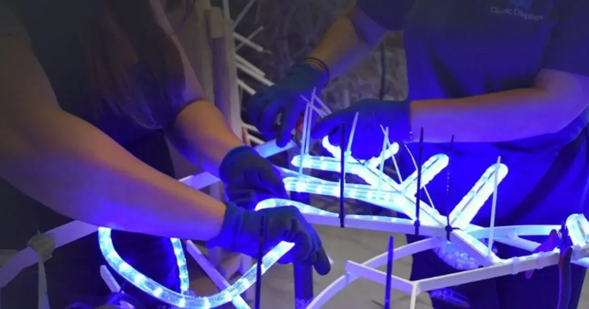 Workers installing blue LED lights